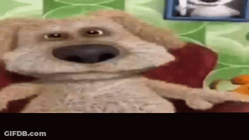 Stuffed Dog Sitting On Red Couch GIF