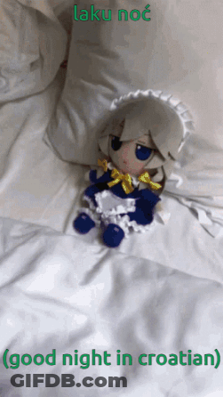 Stuffed Doll Laying On Bed Saying Good Night In Croatian GIF