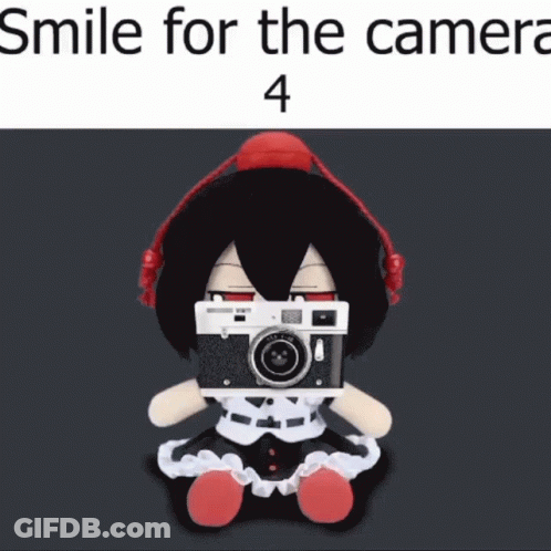 Stuffed Doll With Headphones Holding Camera Smiling GIF