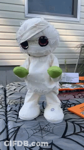 Stuffed Mummy Standing On Spider Web Table Cloth GIF
