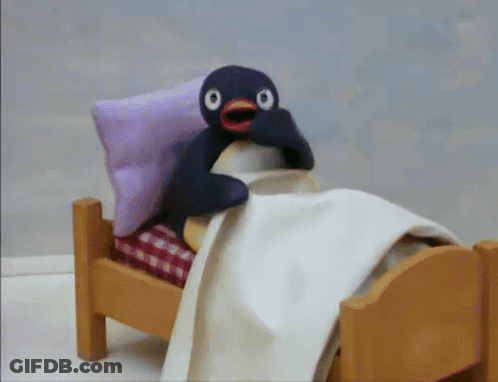 Stuffed Penguin Lying In Bed GIF