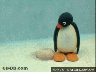 Stuffed Penguin Standing On Rock GIF