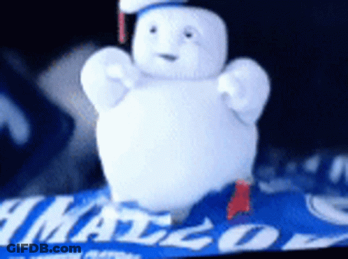 Stuffed Snowman Sitting On Blue Blanket With Mango GIF