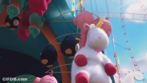 Stuffed Unicorn Sitting In Front Of Roller Coaster GIF