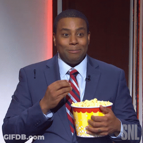 Suit-And-Tie Man Holding Popcorn At SNL Sign GIF