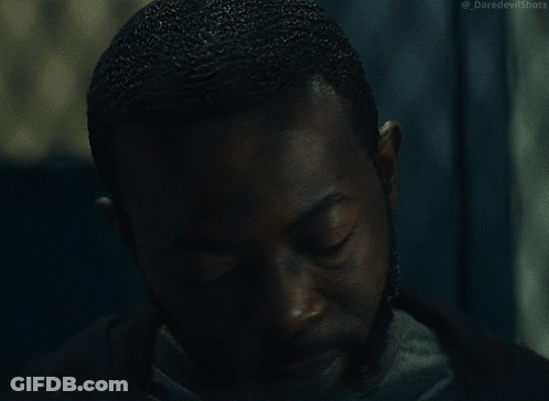 Suit Man Behind Chain Link Fence With Daredevil Shots GIF