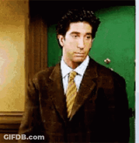 Suit Man Near Green Door Looking At Camera GIF