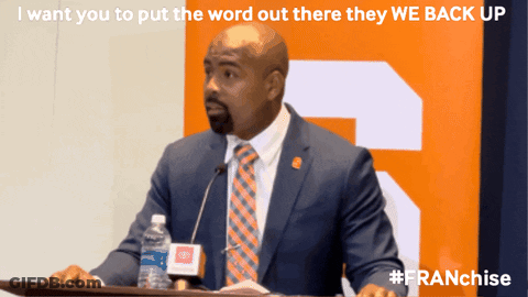 Suited Man At Podium With Water Bottle GIF