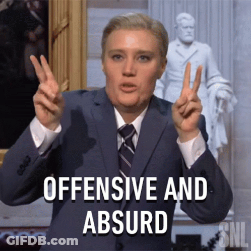 Suited Man Making Peace Sign Saying Offensive Absurd GIF