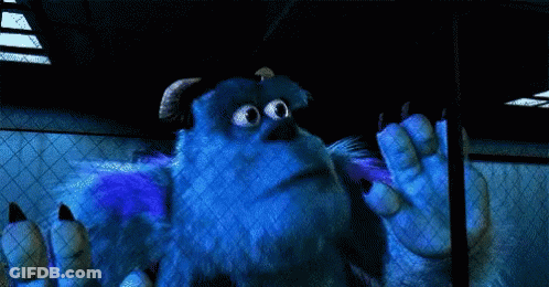 Sulley From Monsters Inc Is Standing In A Dark Room With His Hands Outstretched . GIF