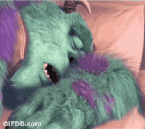 Sulley From Monsters Inc Laying On A Bed With His Mouth Open GIF