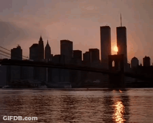 Sun Setting Behind Twin Towers And Bridge GIF
