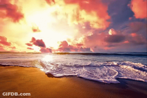 Sun Setting Over Ocean Waves Crashing On Sand GIF