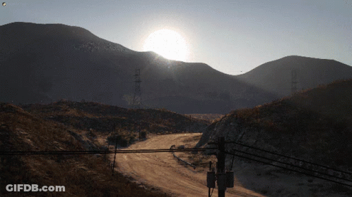Sun Shining Over Mountains And Power Lines GIF