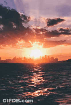Sunset Over Ocean With Distant City GIF