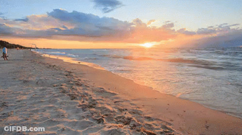 Sunset Over Ocean With Person Walking On Beach GIF