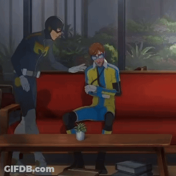 Superhero Man And Another Man On Red Couch GIF