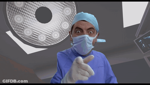 Surgeon In Mask And Gloves Pointing At Camera GIF