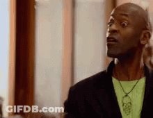 Surprised Man With Black Jacket Green Shirt Skull Necklace GIF