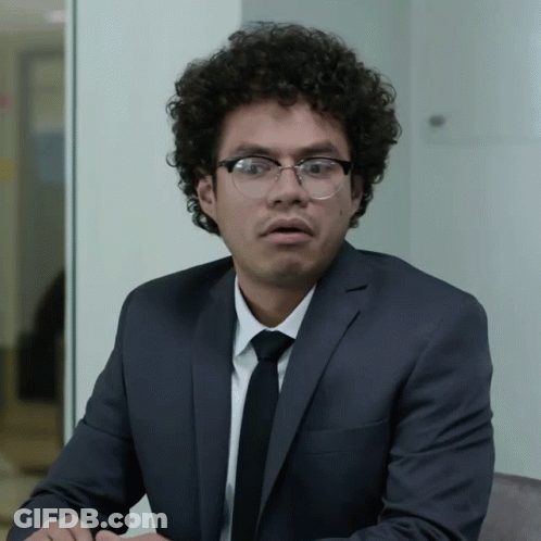 Surprised Man With Curly Hair And Glasses In Suit GIF
