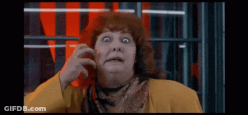 Surprised Red-Haired Woman In Yellow Jacket And Scarf GIF