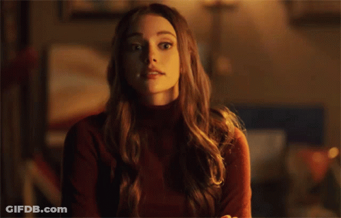 Surprised Woman In Red Sweater Looking At Camera GIF