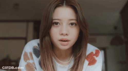 Surprised Woman In White Sweater With Flowers GIF