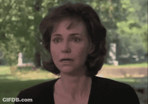 Surprised Woman Standing In Front Of Cemetery GIF