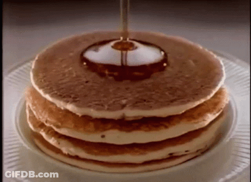 Syrup Is Being Poured On A Stack Of Pancakes On A Plate . GIF