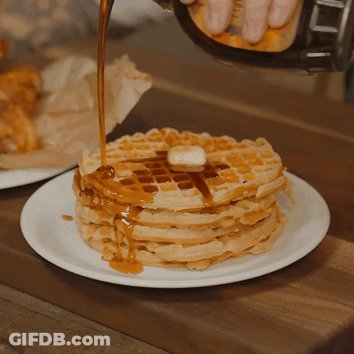 Syrup Is Being Poured On A Stack Of Waffles With Butter GIF