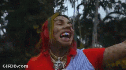 Tattooed Man Laughing In Front Of Trees GIF