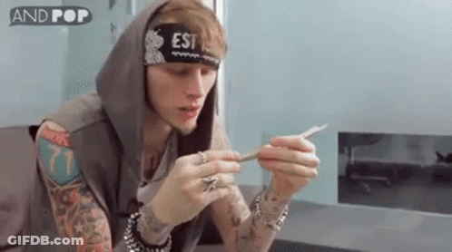 Tattooed Man Smoking Cigarette With Headband And Hoodie GIF