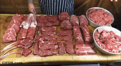 Tattooed Person Standing By Meat Table GIF