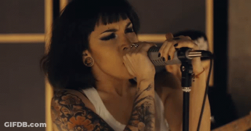 Tattooed Woman Singing Into Microphone GIF