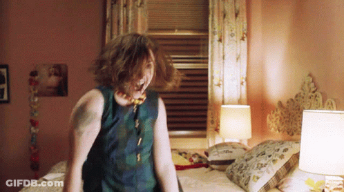 Tattooed Woman Standing On Bed GIF