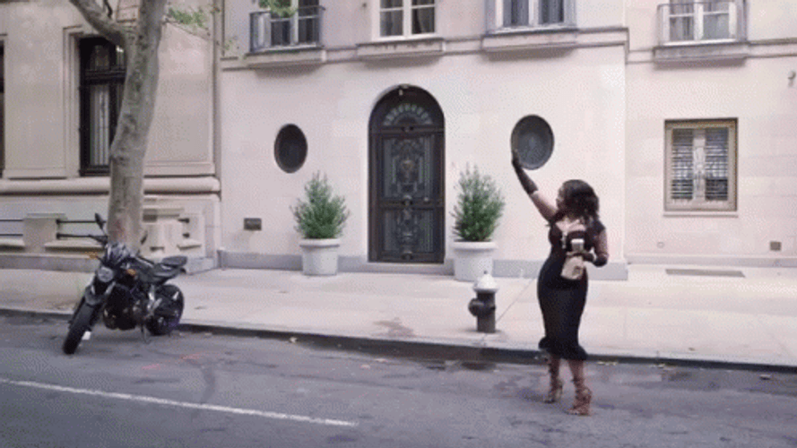 Taxi Driving Past Woman In Dress GIF