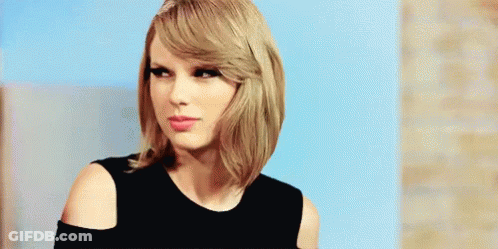Taylor Swift In Black Off-Shoulder Top Looking At Camera GIF