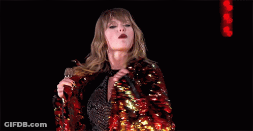 Taylor Swift In Red Sequined Jacket Holding Microphone GIF