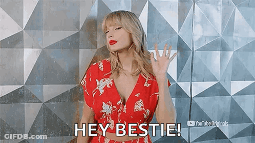 Taylor Swift Is Wearing A Red Floral Dress And Waving At The Camera . GIF