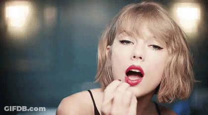 Taylor Swift Is Wearing Red Lipstick And Applying It To Her Lips . GIF