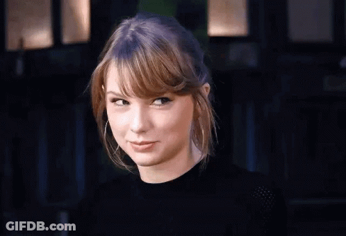 Taylor Swift Making Funny Face In Black Shirt And Hoop Earrings GIF