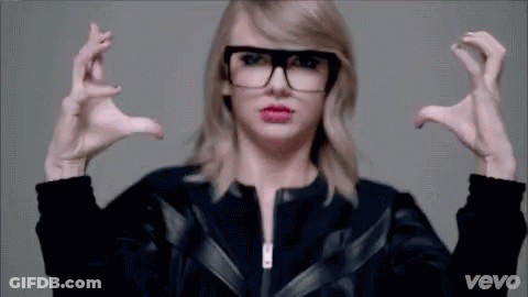 Taylor Swift Sitting On Couch In Black And White Sweater GIF