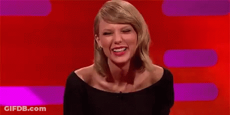 Taylor Swift Smiling In Front Of Red Background GIF
