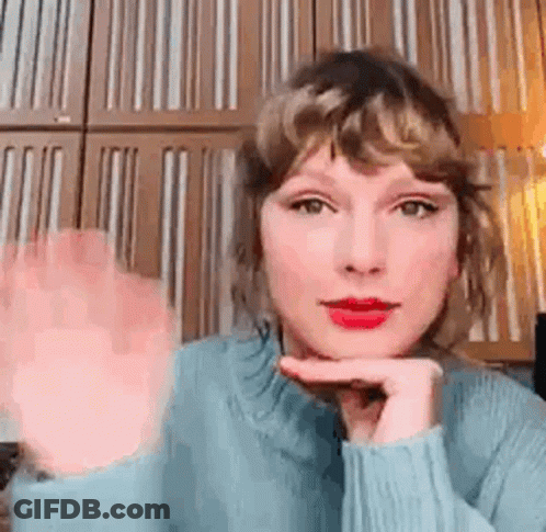 Taylor Swift Waving In Blue Sweater And Red Lipstick GIF