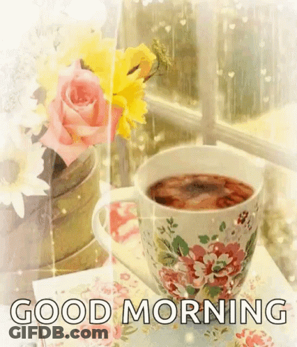 Tea Cup And Vase Of Flowers Near Window GIF