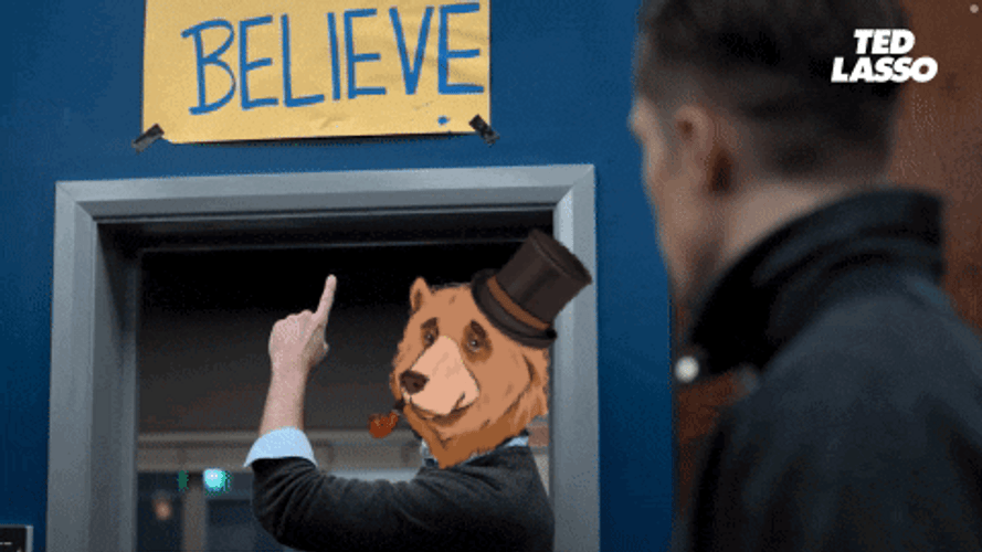 Ted Lasso Bear Head Points At Believe Sign GIF