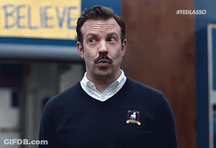 Ted Lasso Peeks At Believe Sign GIF