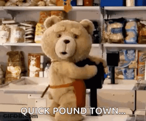 Teddy Bear In Apron Holding Black Object In Store GIF