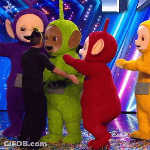 Teletubbies Hugging Man On Stage GIF