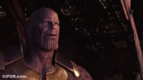 Thanos From Avengers : Age Of Ultron Is Standing In The Dark With His Eyes Closed And A Beard . GIF
